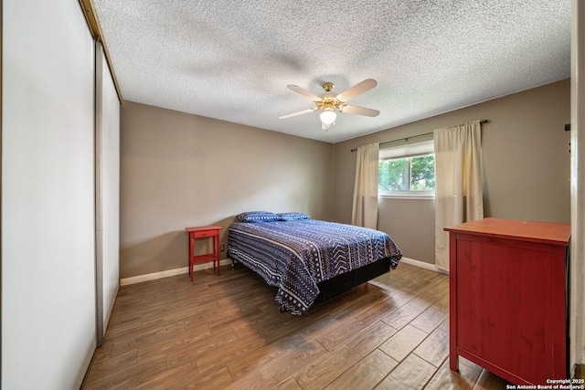 2102 Oak Wild St, San Antonio, TX 78232 - bedroom with wood finished floors, baseboards, a textured ceiling, and a ceiling fan