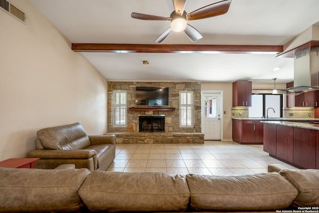 2102 Oak Wild St, San Antonio, TX 78232 - living room featuring beam ceiling, a ceiling fan, light tile patterned flooring, and a stone fireplace