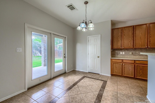 112 Springtree Bnd, Cibolo, TX 78108 - kitchen featuring brown cabinets, a chandelier, decorative light fixtures, light countertops, and tasteful backsplash