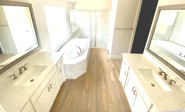 1185 Abelia, New Braunfels, TX 78132 - full bathroom with wood finished floors, two vanities, a shower stall, and a garden tub