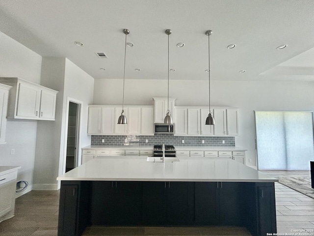 1185 Abelia, New Braunfels, TX 78132 - kitchen featuring stainless steel appliances, tasteful backsplash, light wood-style flooring, a spacious island, and recessed lighting