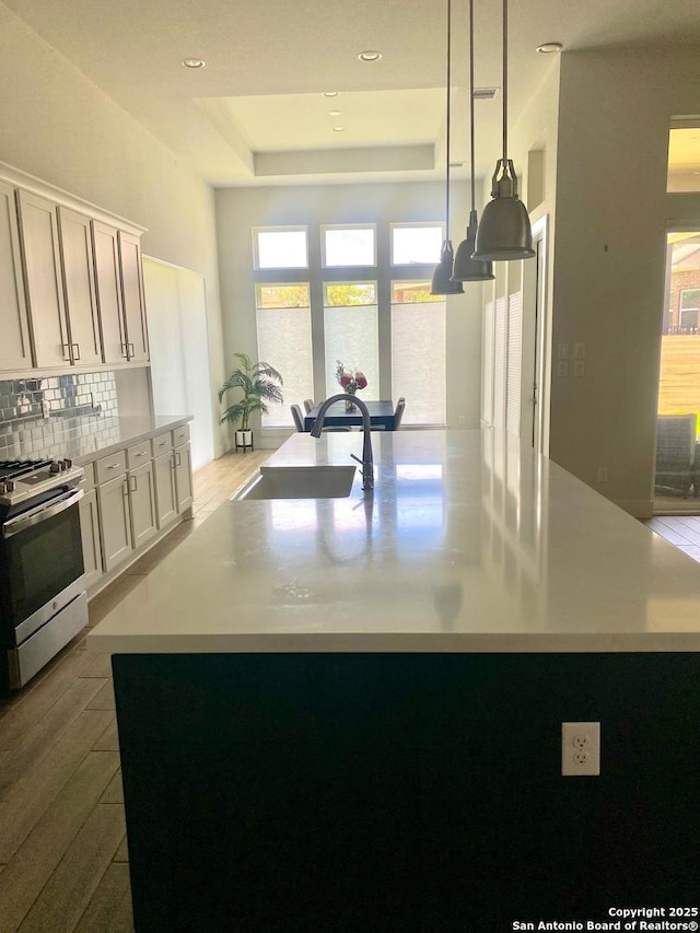 1185 Abelia, New Braunfels, TX 78132 - kitchen with gas stove, a raised ceiling, a sink, light countertops, and recessed lighting