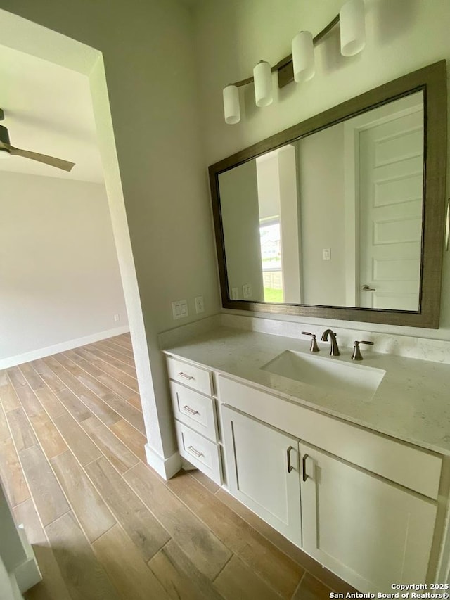 1185 Abelia, New Braunfels, TX 78132 - bathroom with vanity, wood finished floors, baseboards, and a ceiling fan