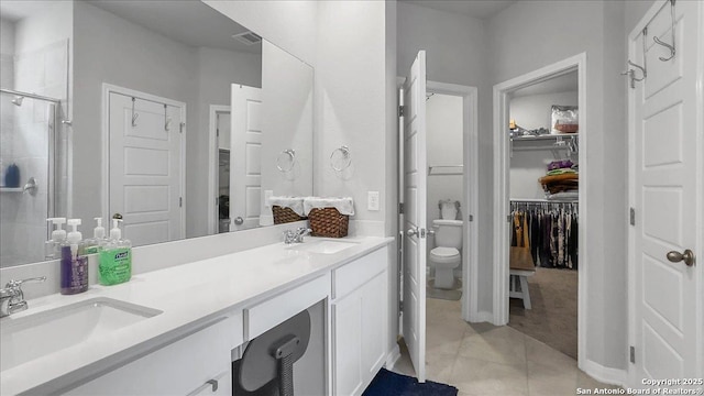 229 Colebrook Way, Cibolo, TX 78108 - full bathroom with a walk in closet, a shower stall, toilet, double vanity, and tile patterned flooring