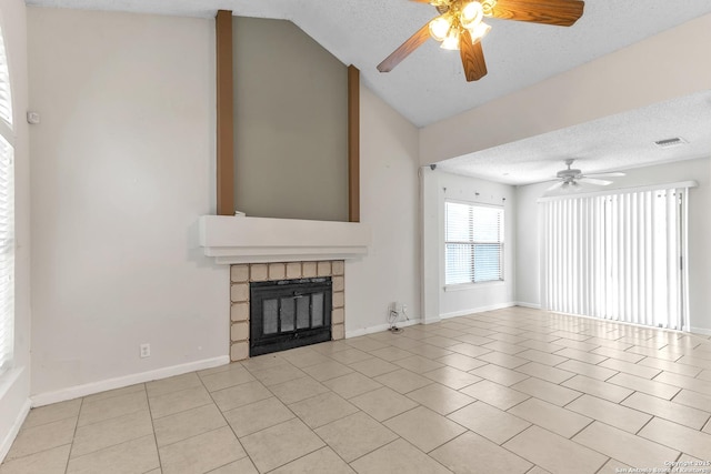 10222 Canton Fld, San Antonio, TX 78245 - unfurnished living room featuring a ceiling fan, a textured ceiling, a stone fireplace, lofted ceiling, and light tile patterned flooring