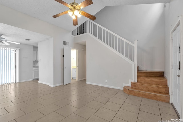 10222 Canton Fld, San Antonio, TX 78245 - unfurnished living room featuring ceiling fan, a textured ceiling, stairway, light tile patterned floors, and baseboards