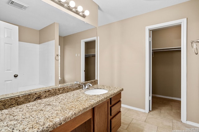 1215 Dezarae St, San Antonio, TX 78253 - full bathroom featuring vanity, baseboards, a spacious closet, a tile shower, and tile patterned flooring