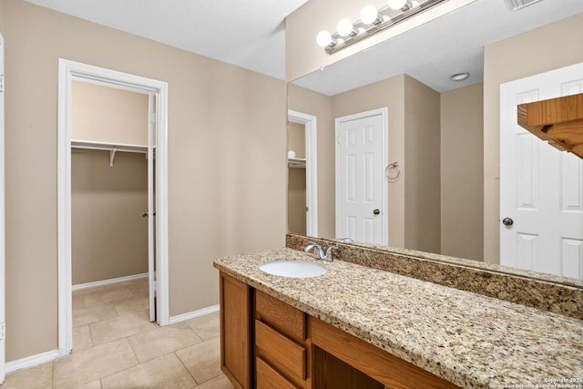 1215 Dezarae St, San Antonio, TX 78253 - bathroom with vanity, baseboards, a spacious closet, and tile patterned flooring