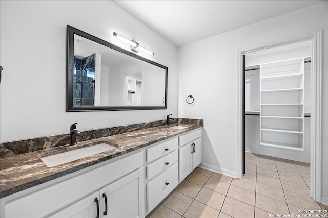 268 Cordova Loop, Seguin, TX 78155 - full bathroom with double vanity, tile patterned flooring, baseboards, and a walk in closet