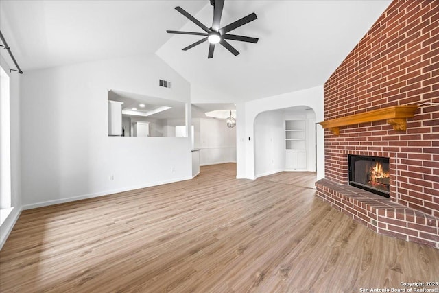 268 Cordova Loop, Seguin, TX 78155 - unfurnished living room with ceiling fan, a brick fireplace, baseboards, wood finished floors, and arched walkways
