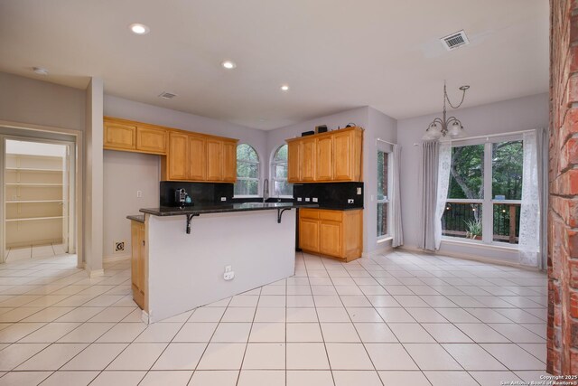 15808 Mission Rdg, San Antonio, TX 78232 - kitchen with tasteful backsplash, a chandelier, a breakfast bar area, recessed lighting, and light tile patterned floors