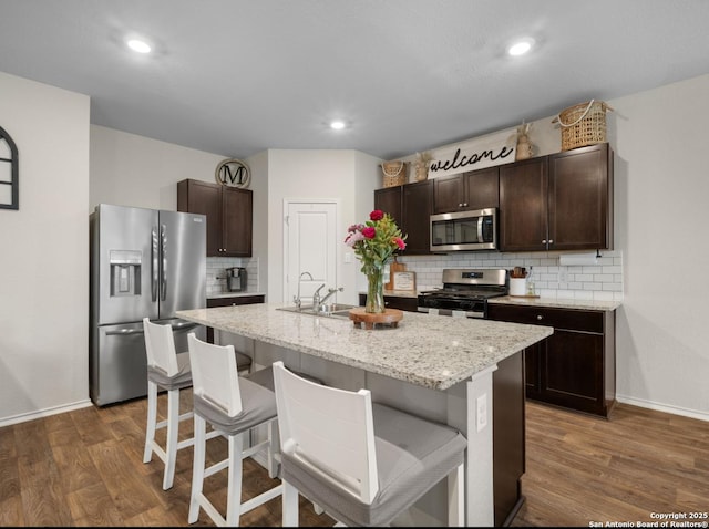 6416 Embankment, San Antonio, TX 78252 - kitchen with stainless steel appliances, a sink, baseboards, decorative backsplash, and dark wood-type flooring