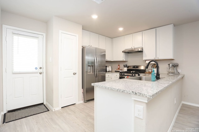 1206 Kiskadee Way, San Antonio, TX 78245 - kitchen featuring appliances with stainless steel finishes, under cabinet range hood, baseboards, a peninsula, and a sink
