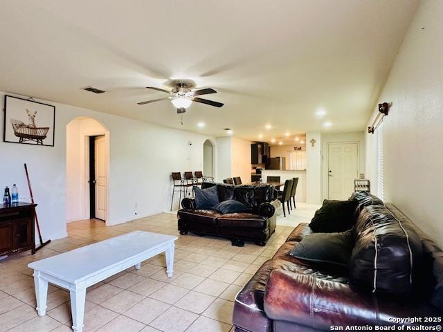 15134 Silver Tree, Von Ormy, TX 78073 - living area featuring arched walkways, light tile patterned flooring, ceiling fan, and recessed lighting