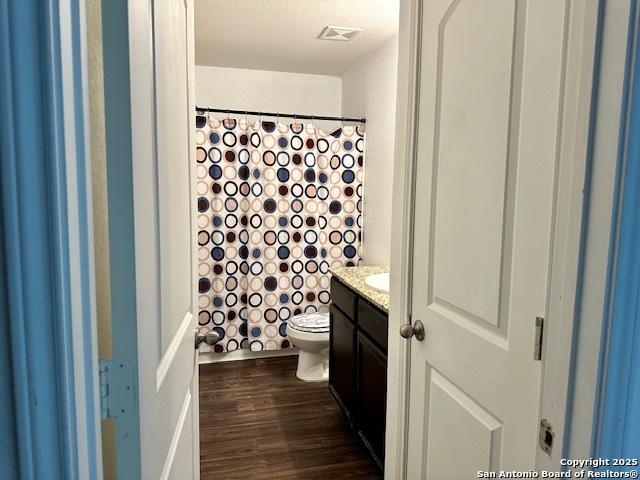 15134 Silver Tree, Von Ormy, TX 78073 - full bath with toilet, vanity, wood finished floors, and a shower with shower curtain