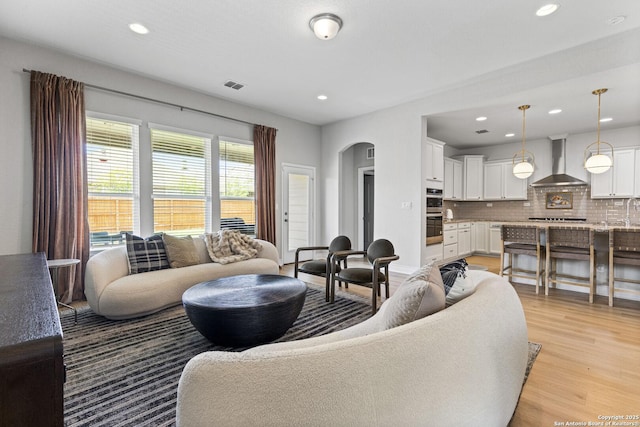 7618 Desperado, Boerne, TX 78015 - living room with arched walkways, light wood-style flooring, and recessed lighting