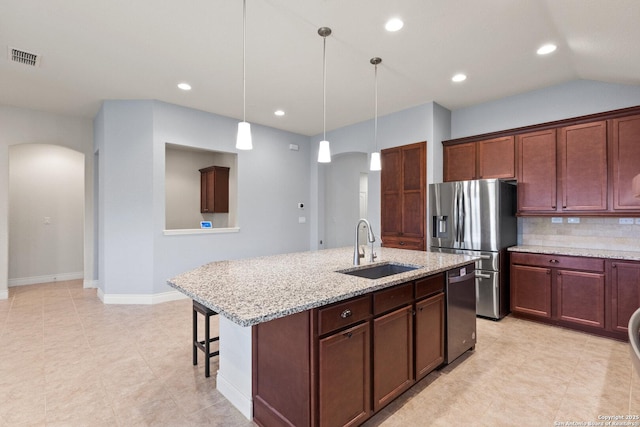 122 Braeburn, Boerne, TX 78015 - kitchen featuring a sink, arched walkways, appliances with stainless steel finishes, light stone countertops, and tasteful backsplash