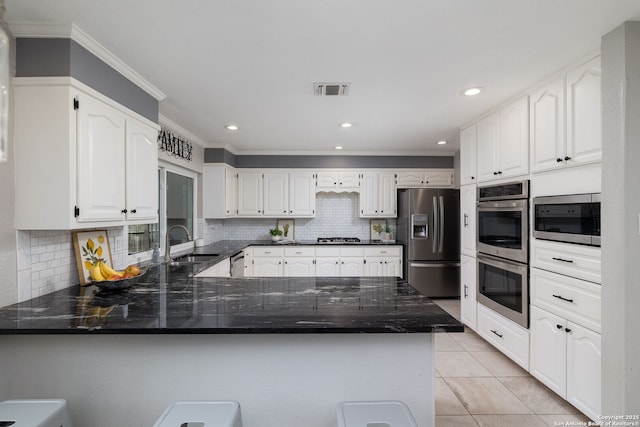 611 San Diego, San Antonio, TX 78232 - kitchen with appliances with stainless steel finishes, a peninsula, a sink, ornamental molding, and dark stone countertops