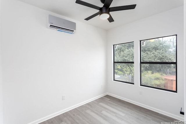 155 Vine St, San Antonio, TX 78210 - spare room featuring a wall unit AC, wood finished floors, a ceiling fan, and baseboards