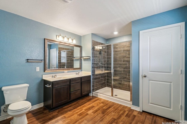 9321 Devils Riv, Converse, TX 78109 - full bathroom featuring toilet, a shower stall, double vanity, wood finished floors, and baseboards