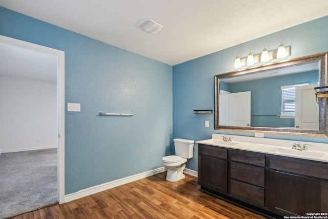 9321 Devils Riv, Converse, TX 78109 - full bathroom with double vanity, toilet, wood finished floors, and baseboards