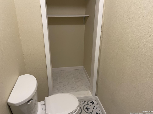 1538 Thorain, San Antonio, TX 78201 - bathroom featuring toilet, marble look tile flooring, and baseboards