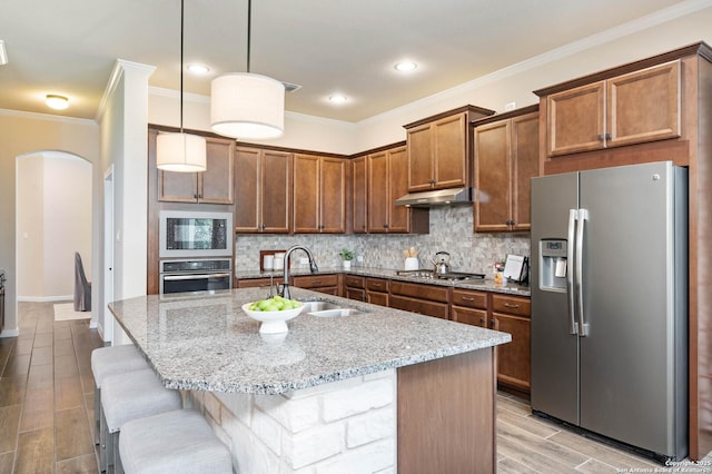 25318 Pleasant Bch, San Antonio, TX 78255 - kitchen featuring stainless steel appliances, a sink, under cabinet range hood, arched walkways, and light stone counters