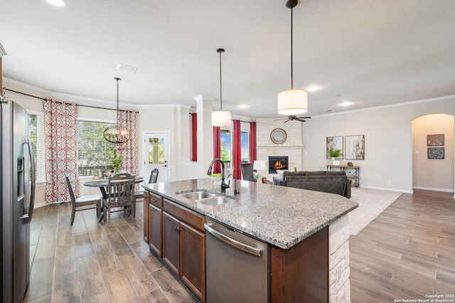 25318 Pleasant Bch, San Antonio, TX 78255 - kitchen with stainless steel appliances, a sink, a large fireplace, baseboards, and ornamental molding