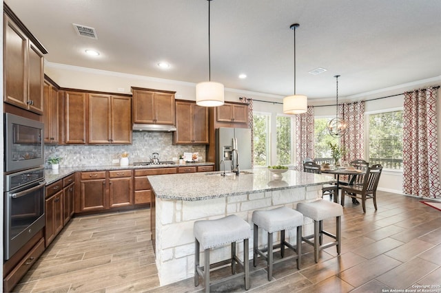 25318 Pleasant Bch, San Antonio, TX 78255 - kitchen featuring stainless steel appliances, a sink, a kitchen bar, crown molding, and under cabinet range hood