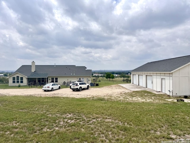 187 Tracks Trl, Center Point, TX 78010 - view of grassy yard featuring a garage, driveway, and an outbuilding