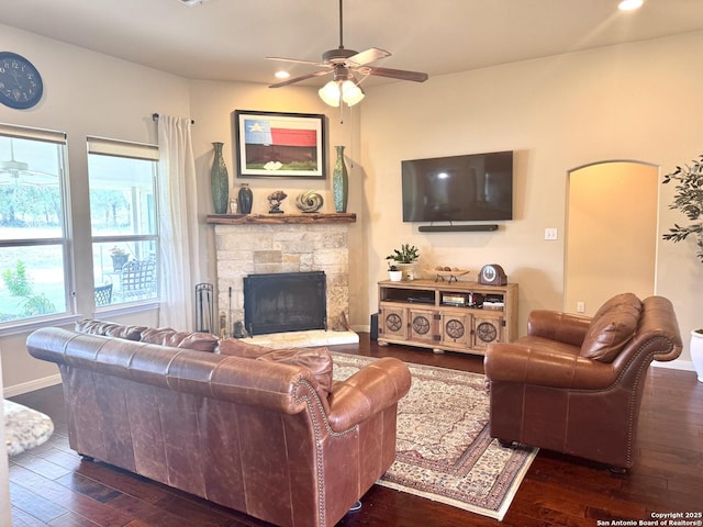 187 Tracks Trl, Center Point, TX 78010 - living room featuring ceiling fan, dark wood-type flooring, a stone fireplace, baseboards, and recessed lighting