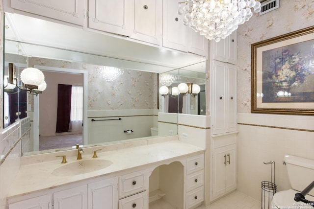 2150 W Summit Ave, San Antonio, TX 78201 - bathroom featuring wallpapered walls, a chandelier, toilet, wainscoting, and vanity