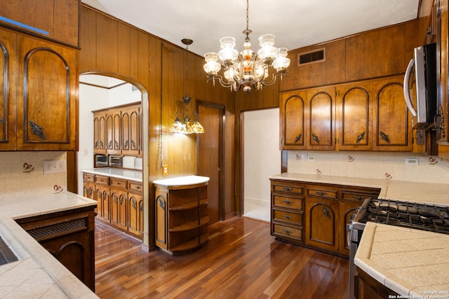2150 W Summit Ave, San Antonio, TX 78201 - kitchen featuring stainless steel appliances, backsplash, dark wood-style floors, arched walkways, and wooden walls