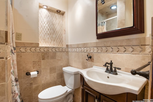 2150 W Summit Ave, San Antonio, TX 78201 - full bathroom featuring tile walls, toilet, vanity, a wainscoted wall, and a shower with shower curtain