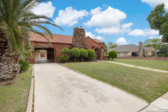 2150 W Summit Ave, San Antonio, TX 78201 - mediterranean / spanish-style house with a tile roof, a front lawn, driveway, a chimney, and brick siding