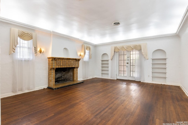 2150 W Summit Ave, San Antonio, TX 78201 - unfurnished living room featuring built in shelves, wood-type flooring, a fireplace, baseboards, and plenty of natural light