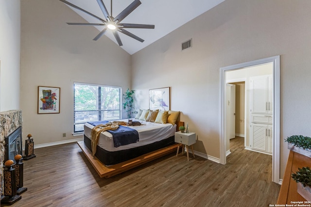 8537 Classic Oaks Ln, San Antonio, TX 78255 - bedroom with high vaulted ceiling, wood finished floors, baseboards, a stone fireplace, and a ceiling fan