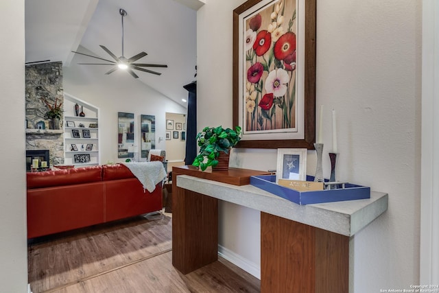 8537 Classic Oaks Ln, San Antonio, TX 78255 - living room with a ceiling fan, vaulted ceiling, wood finished floors, a stone fireplace, and built in features