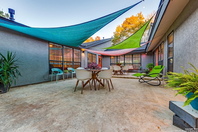8537 Classic Oaks Ln, San Antonio, TX 78255 - sunroom / solarium with outdoor dining area, concrete flooring, and a textured wall
