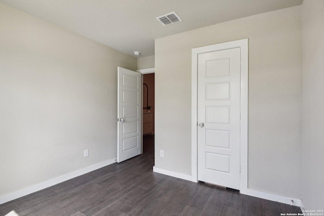 7718 Blue Gulf, San Antonio, TX 78222 - unfurnished bedroom featuring baseboards and dark wood-style flooring