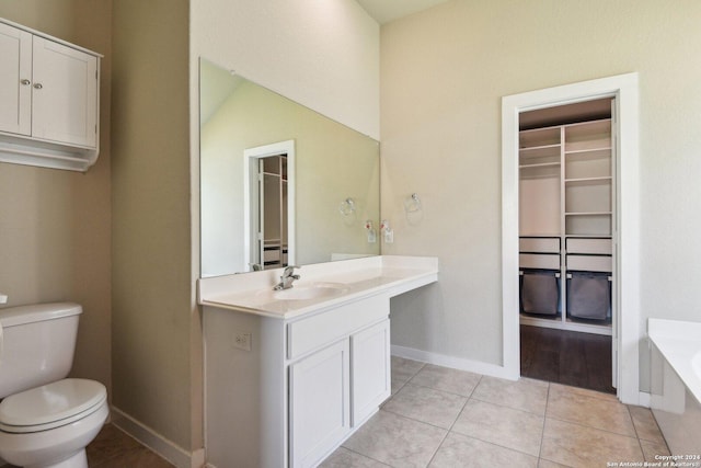 7718 Blue Gulf, San Antonio, TX 78222 - full bathroom featuring toilet, vanity, a bath, tile patterned flooring, and baseboards