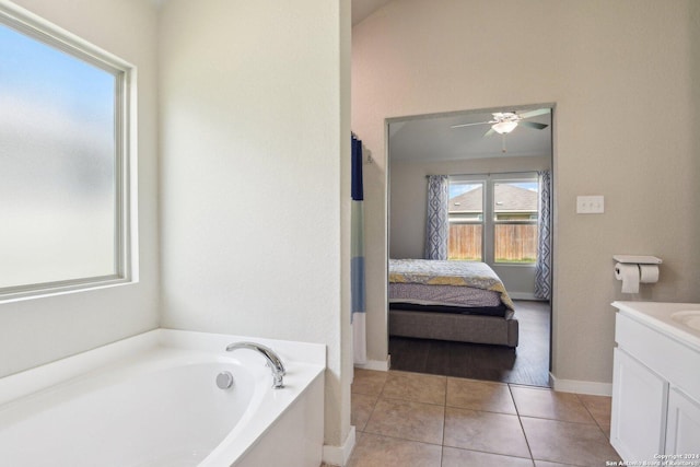 7718 Blue Gulf, San Antonio, TX 78222 - ensuite bathroom with vanity, a bath, a ceiling fan, tile patterned flooring, and baseboards