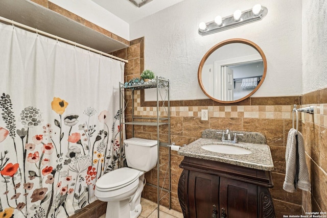 2300 Nacogdoches Rd Unit 164R, San Antonio, TX 78209 - full bathroom with tile walls, toilet, vanity, a shower with shower curtain, and wainscoting
