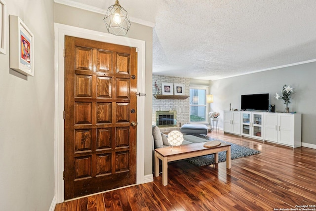 2300 Nacogdoches Rd Unit 164R, San Antonio, TX 78209 - entrance foyer featuring a textured ceiling, wood finished floors, a brick fireplace, baseboards, and ornamental molding