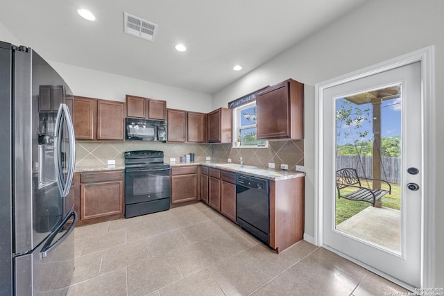 7702 Bit Cir, Elmendorf, TX 78112 - kitchen featuring black appliances, backsplash, recessed lighting, light tile patterned flooring, and a sink