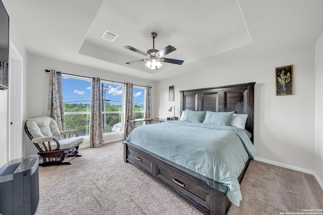 7702 Bit Cir, Elmendorf, TX 78112 - bedroom with a tray ceiling, light colored carpet, baseboards, and a ceiling fan