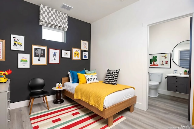 130 E Lachapelle, San Antonio, TX 78204 - bedroom featuring wood finished floors, connected bathroom, and baseboards