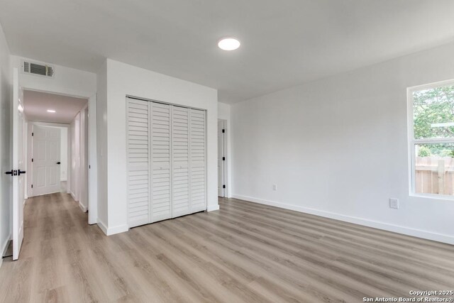 602 John Page, San Antonio, TX 78228 - unfurnished bedroom with light wood finished floors, baseboards, and a closet