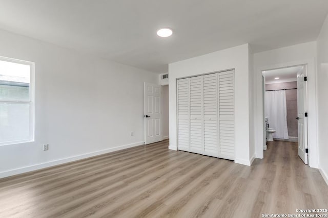 602 John Page, San Antonio, TX 78228 - unfurnished bedroom featuring light wood-style floors, a closet, baseboards, and connected bathroom