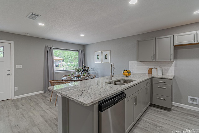 4935 Bartmer Ave, San Antonio, TX 78228 - kitchen featuring stainless steel dishwasher, gray cabinets, a peninsula, light wood-style flooring, and light stone countertops